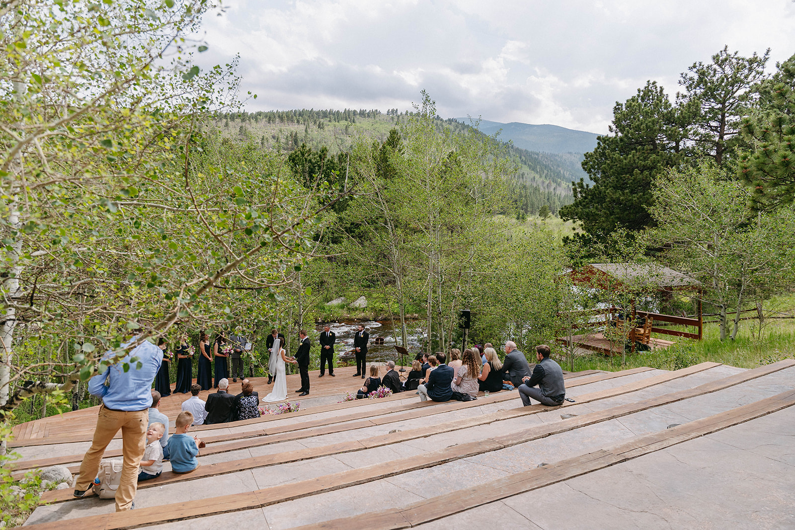 Jason and Amy kissing on the rocks framed by aspen trees